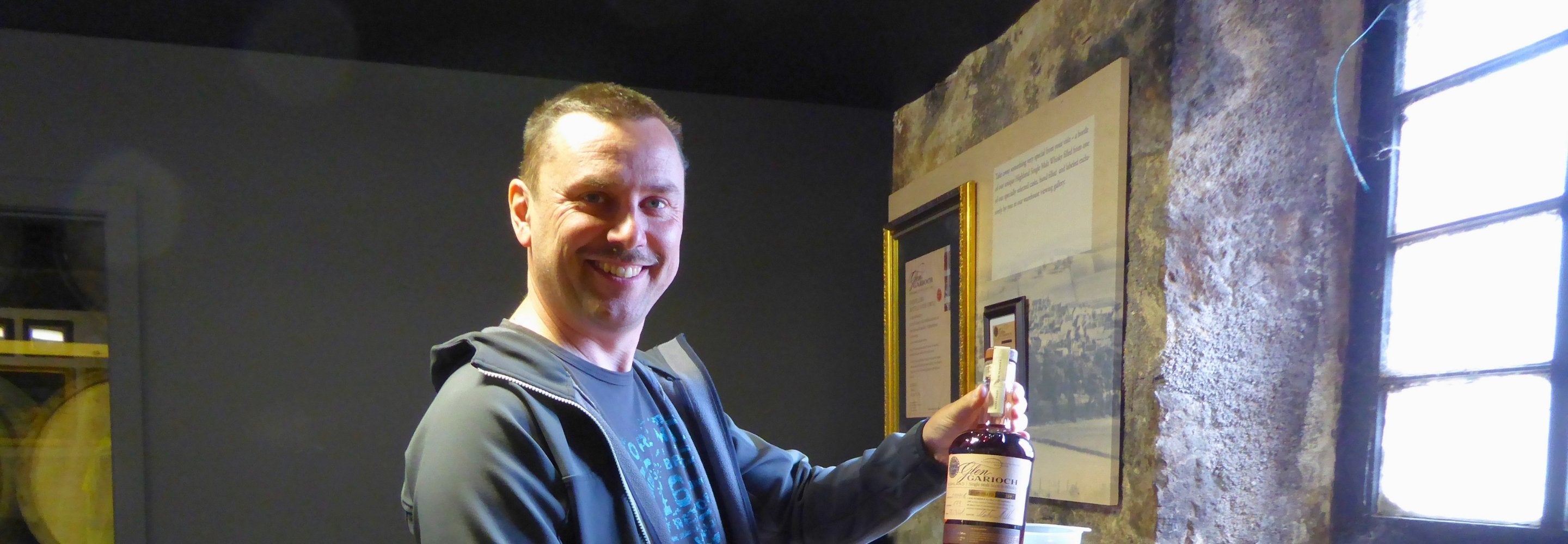 Whisky Connaiseur Markus Müller mit Flasche Whisky in Schottland